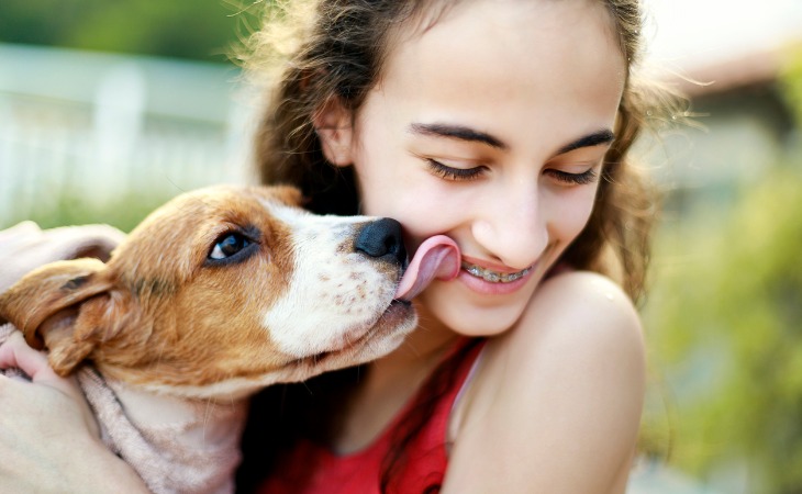 Perro lamiendo a una chica.